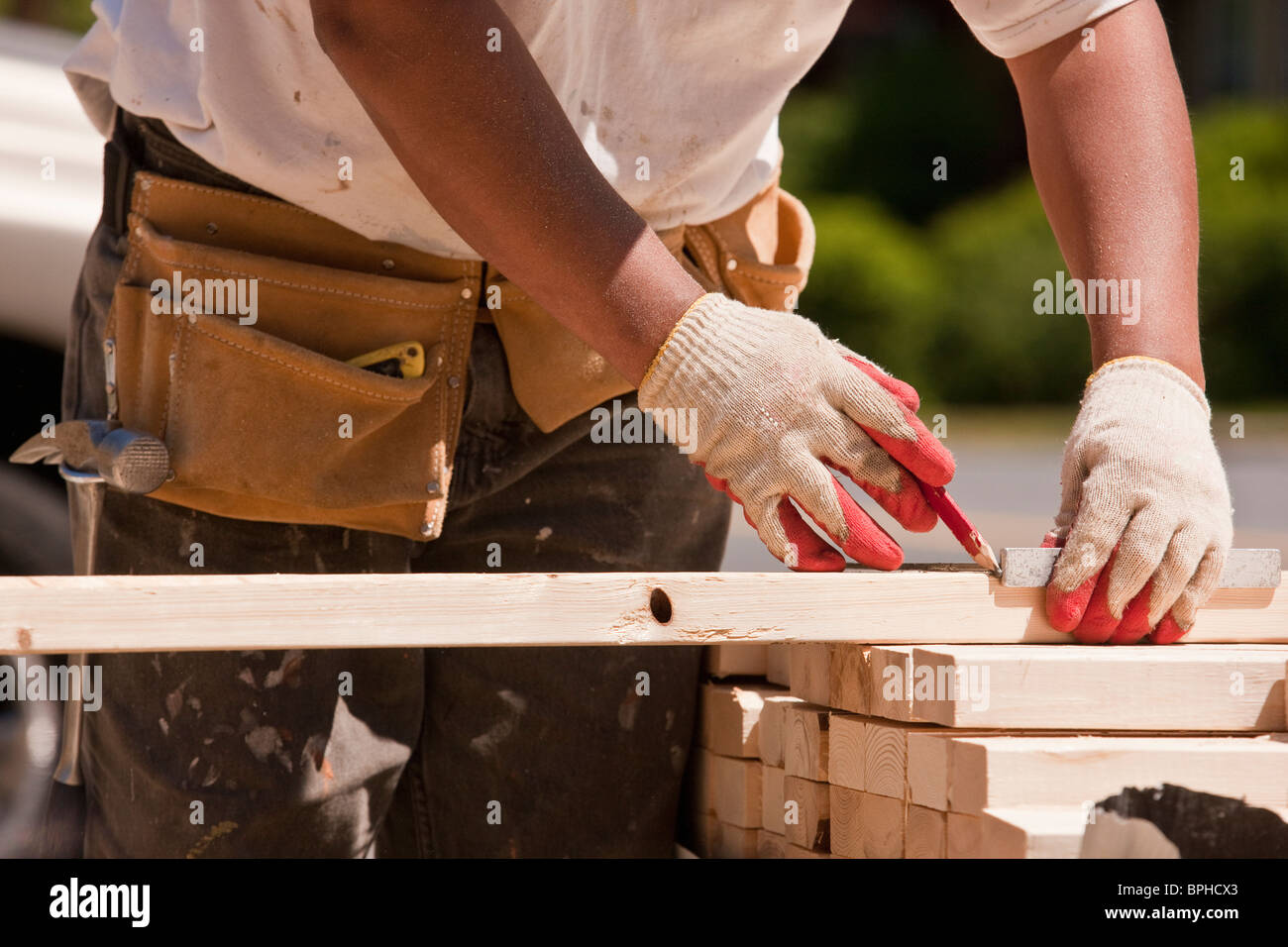 Carpenter measuring wall studs at a construction site Stock Photo Alamy