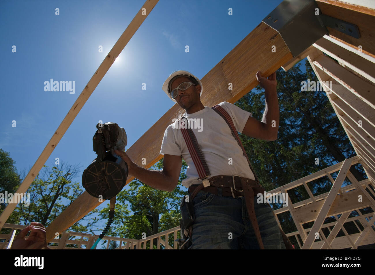 Carpenter using a nail gun at a construction site Stock Photo Alamy