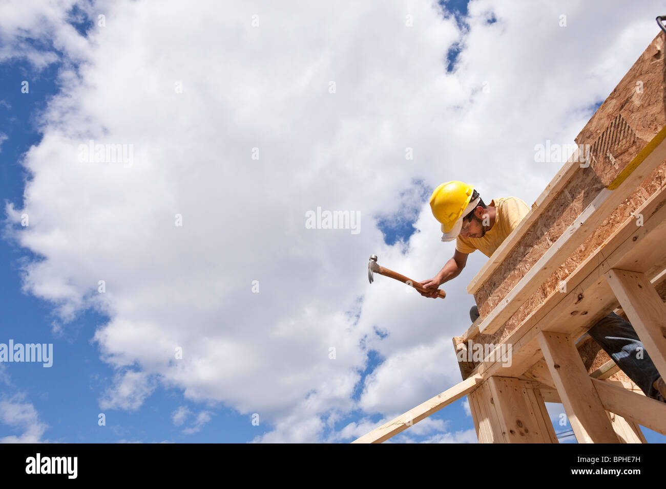 Carpenter hammering on upper floor joists Stock Photo