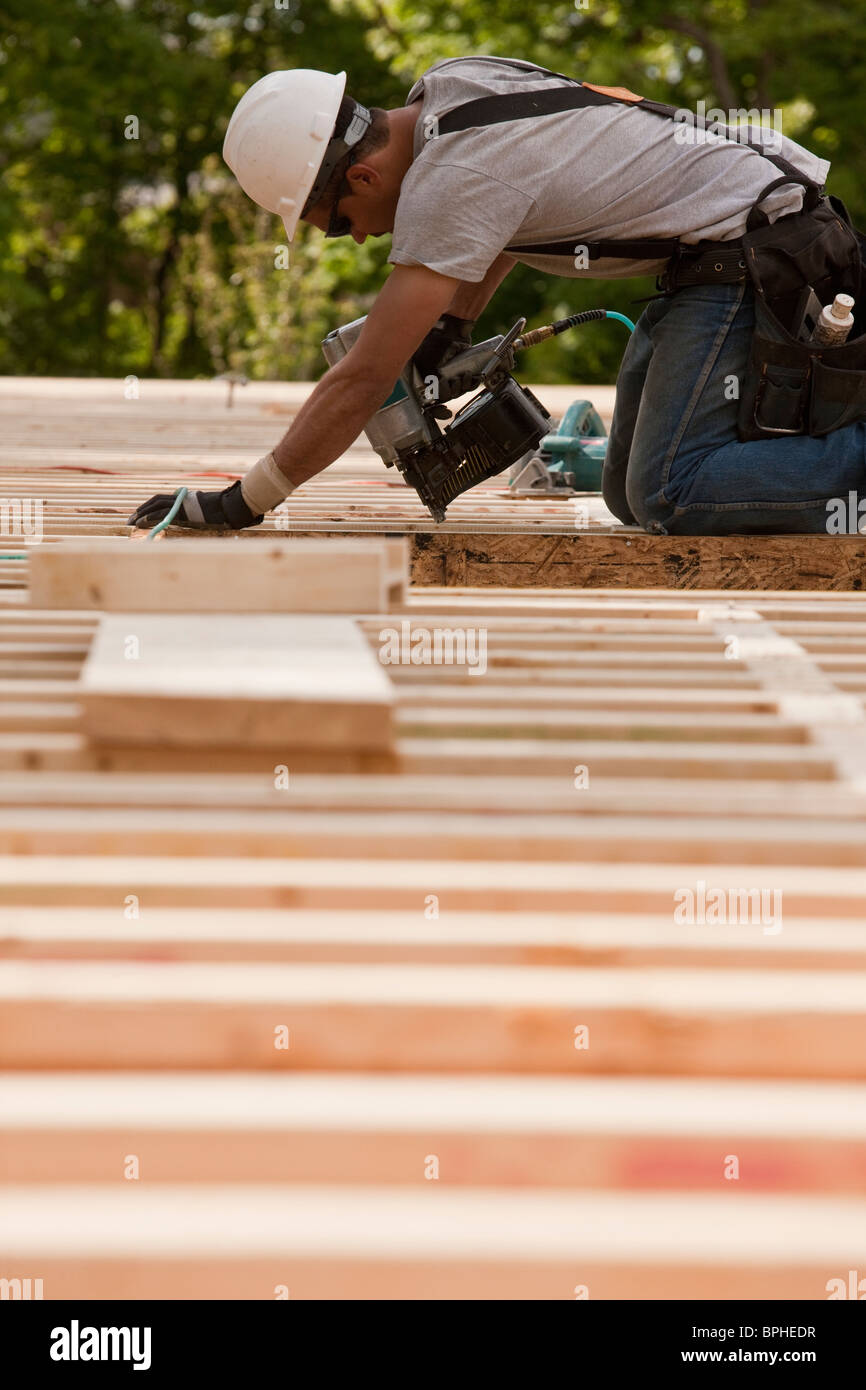 Carpenter using a nail gun at a construction site Stock Photo