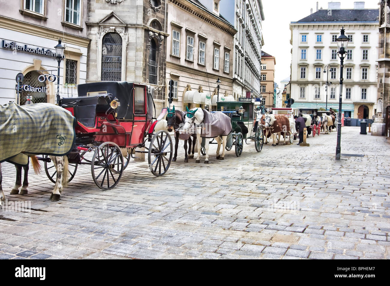 Horses and wagons waiting for tourists in downtown Vienna, Austria. Stock Photo