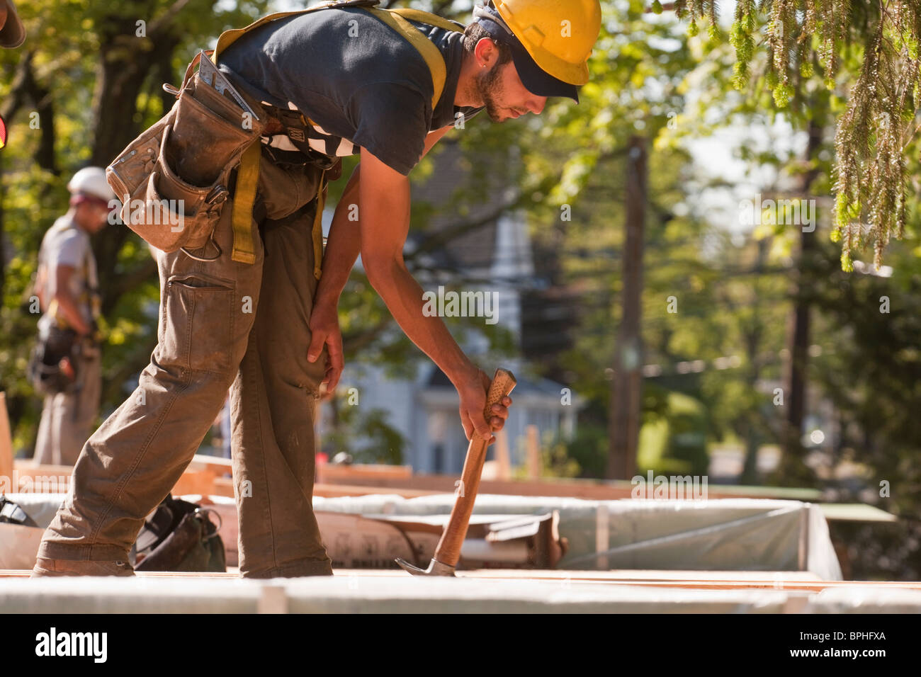 Carpenter using a claw hammer at a construction site Stock Photo Alamy
