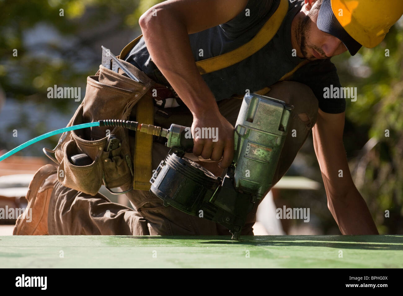 Carpenter using a nail gun at a construction site Stock Photo Alamy