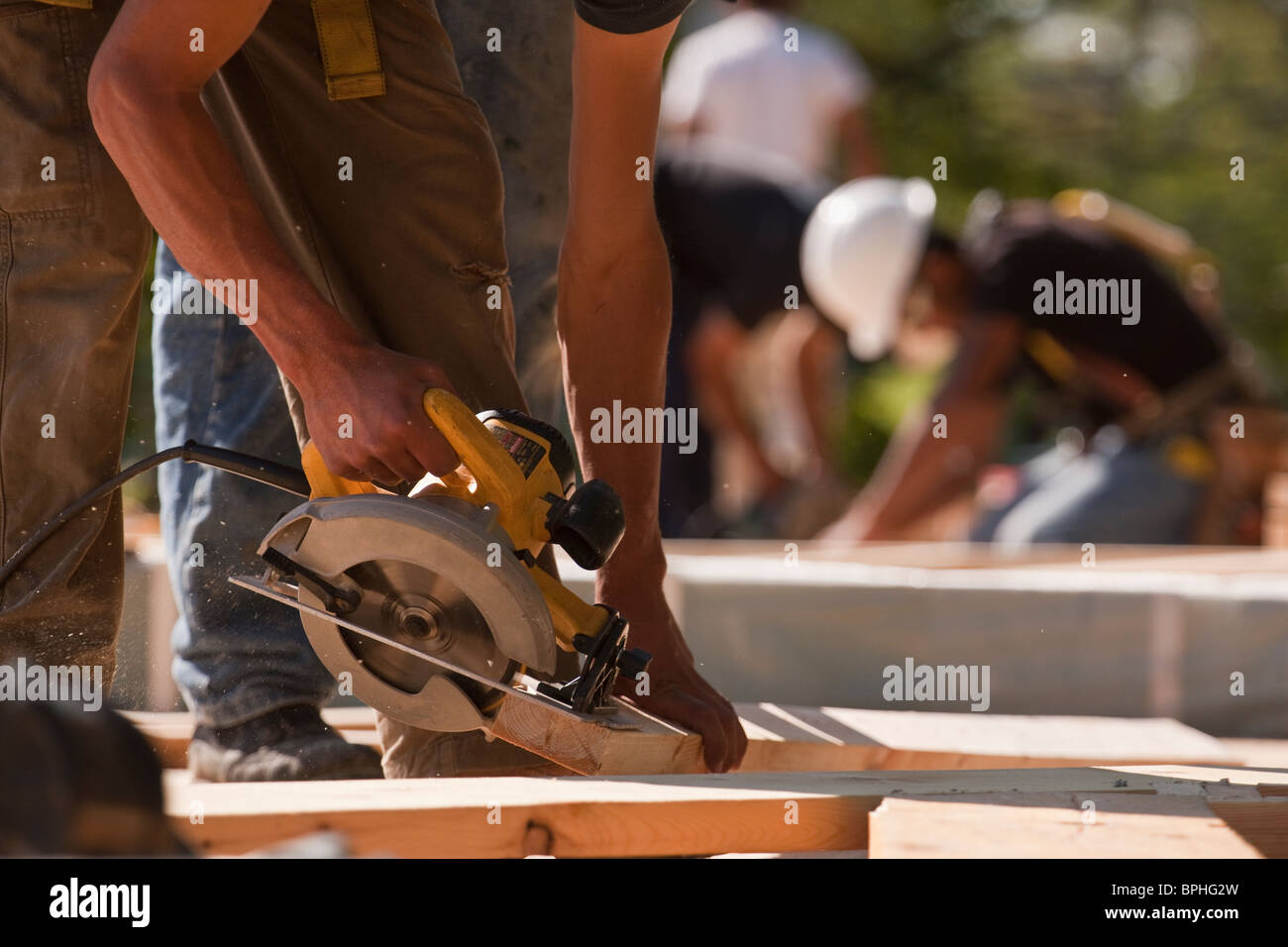 Carpenters using circular saw at a construction site Stock Photo