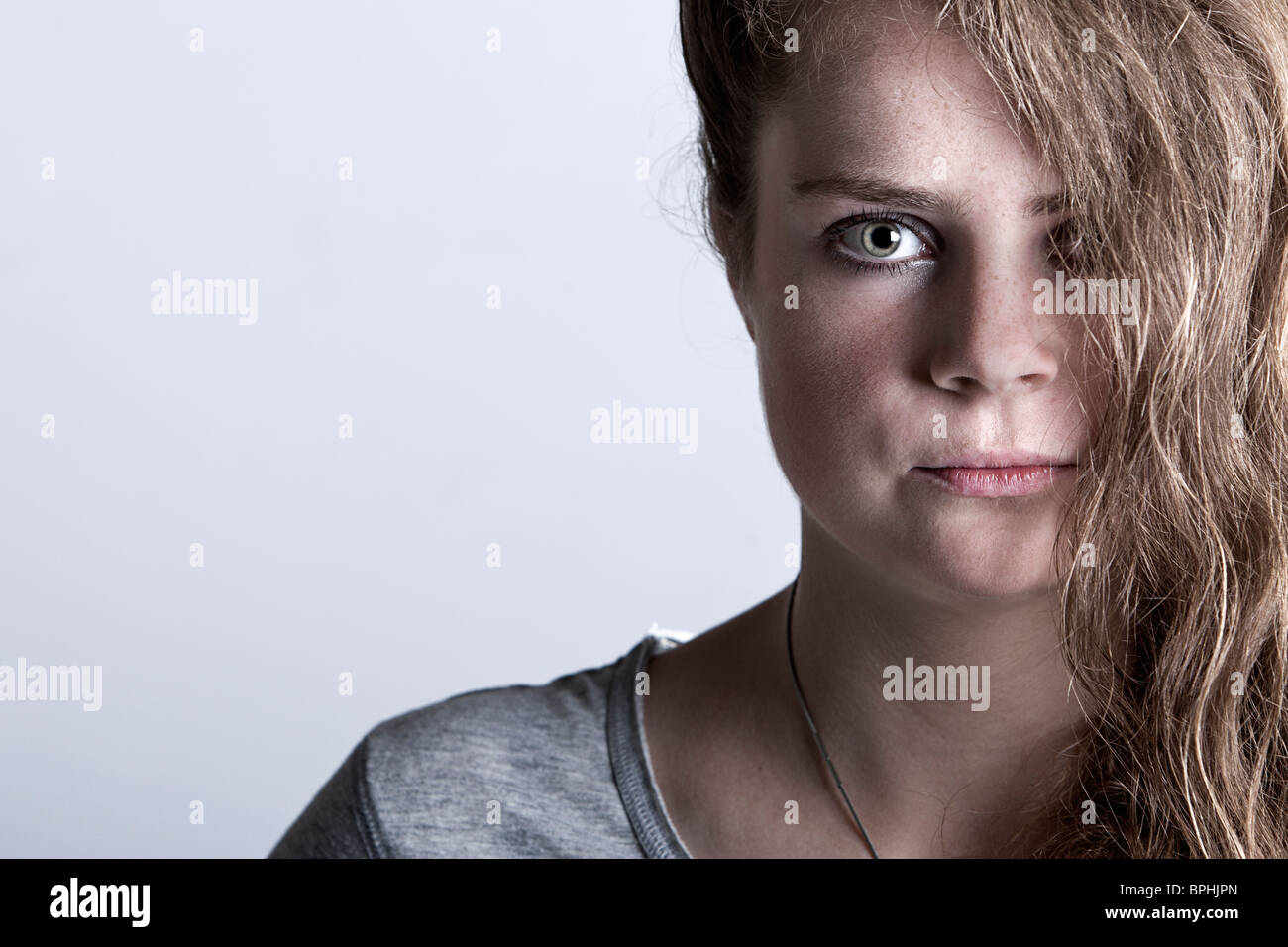 Shot of a Young Woman with her Hair Covering Half of her Face Stock Photo