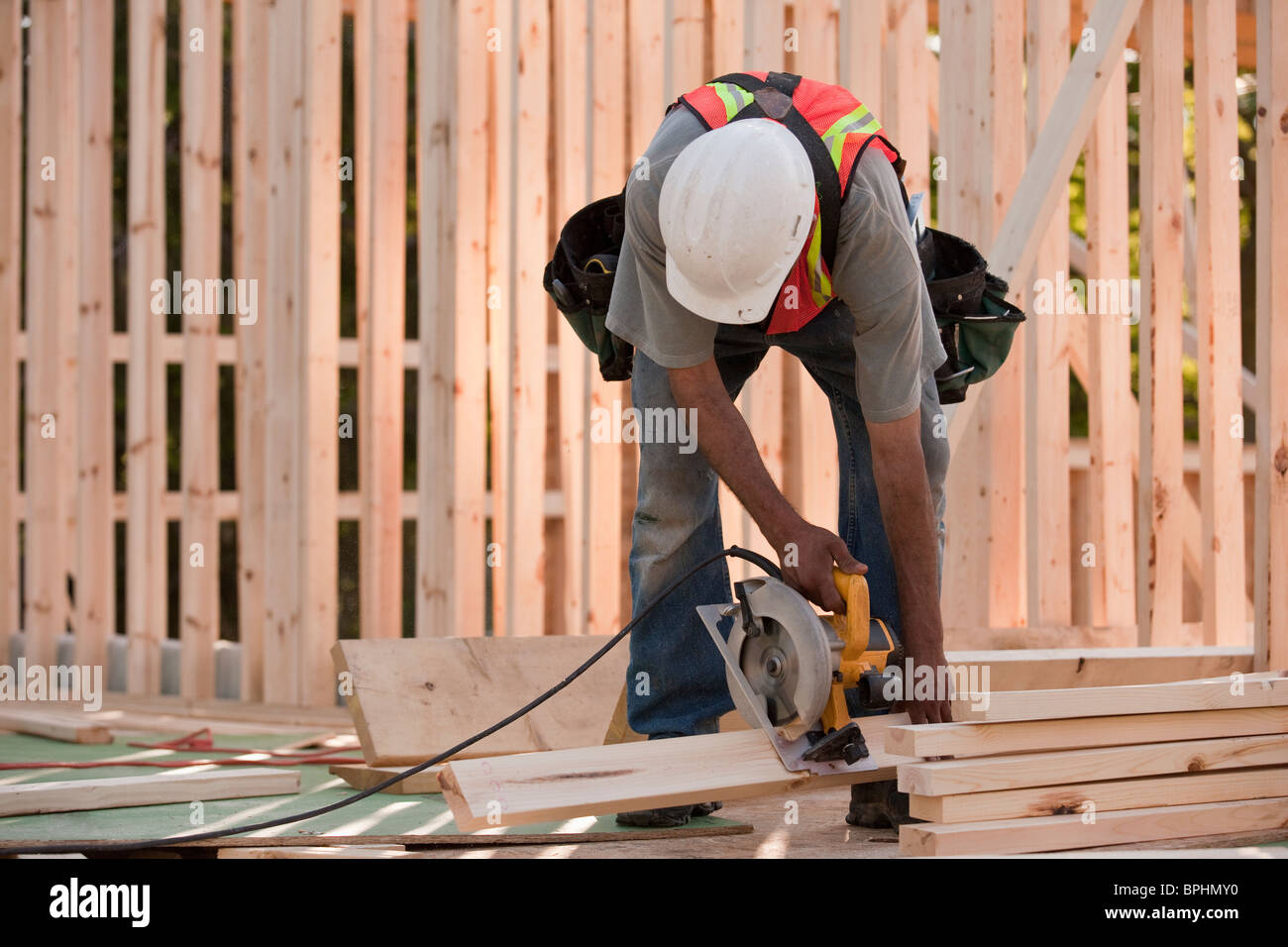 Carpenter sawing wood for house framing Stock Photo Alamy