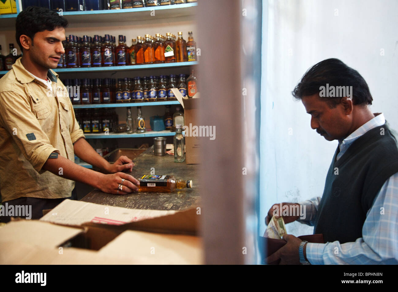 A customer buys a bottle of Indian whisky in a wine shop (liquor store) in Srinagar, Kashmir