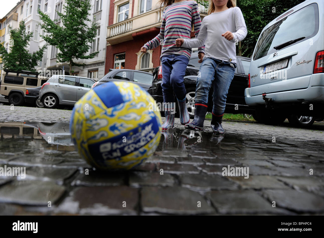 Two girls playing with a ball in the city. Stock Photo