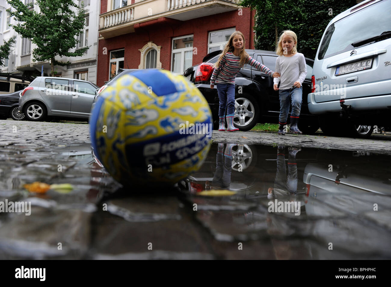 Two girls playing with a ball in the city. Stock Photo