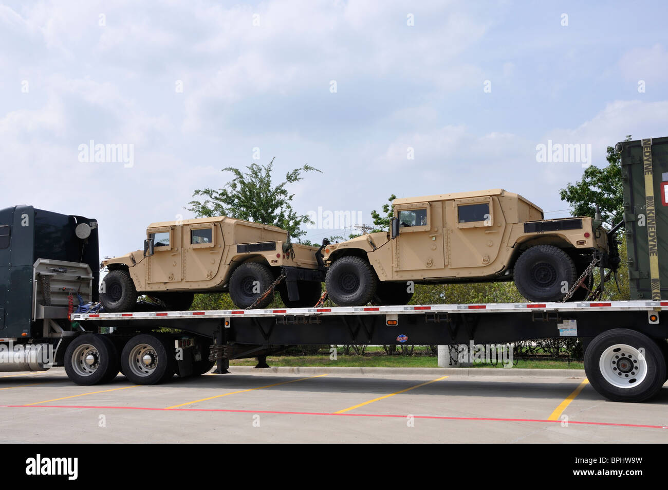 US military trucks being transported on large truck Stock Photo