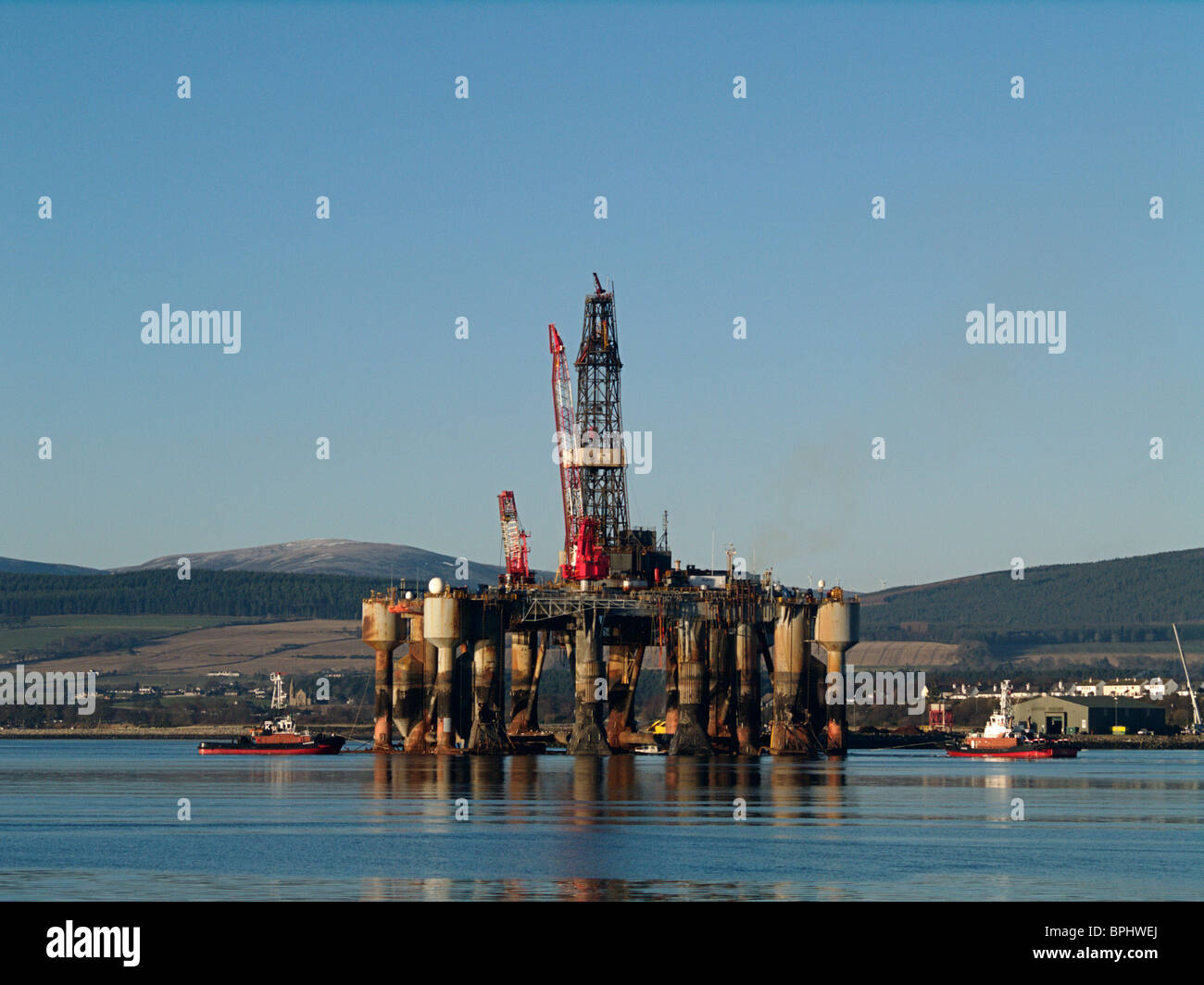 An Oil Rig is maneuvered to its berth by two tugs at the port of