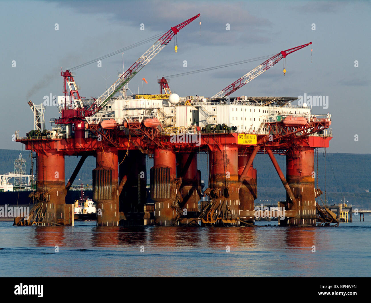 A Flotel, the Borgholm Dolphin, is towed past the Nigg Oil Terminal, in the Cromarty Firth, Scotland Stock Photo