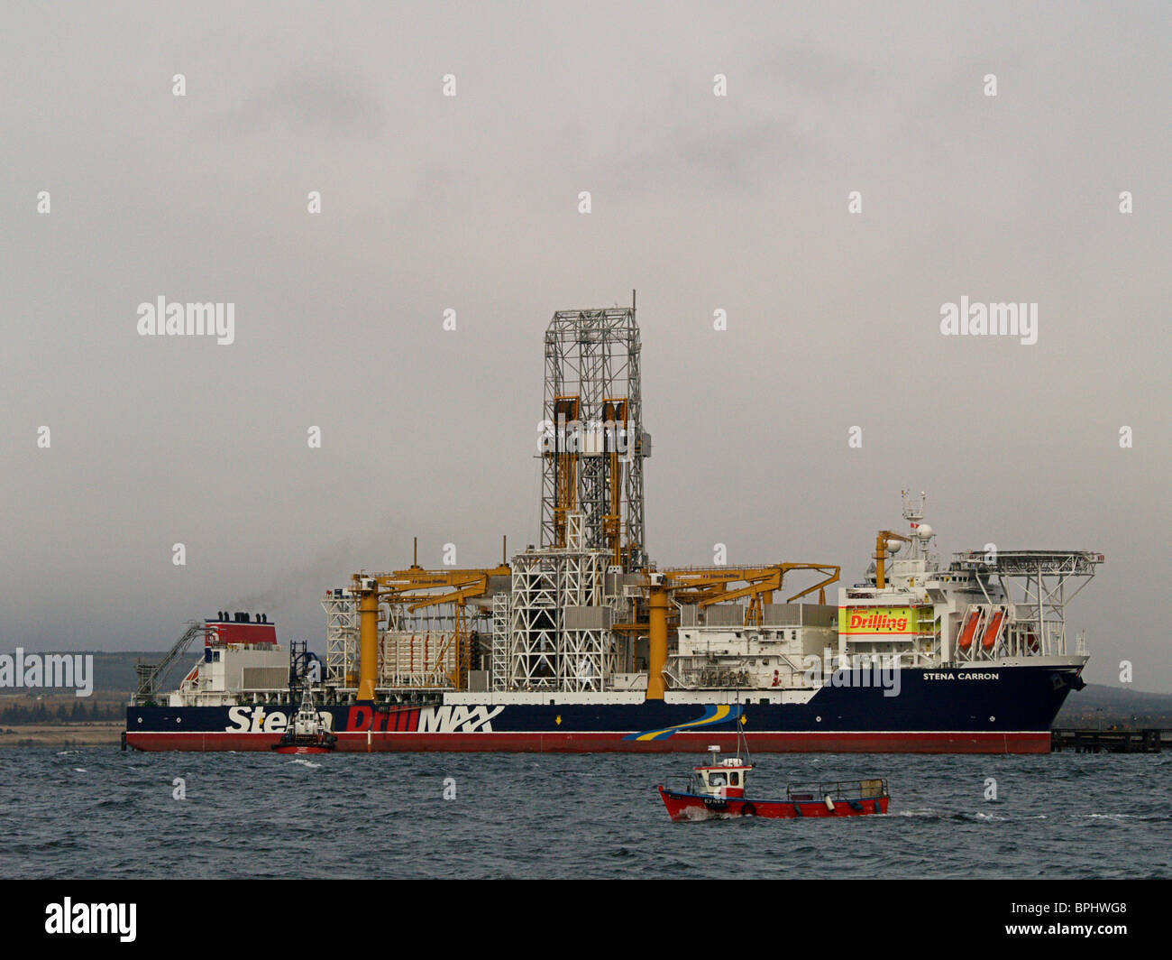 The Stena Carron Oil Drill Ship at the Nigg Oil Terminal, Cromarty Firth Scotland, with a local fishing boat in the foreground. Stock Photo