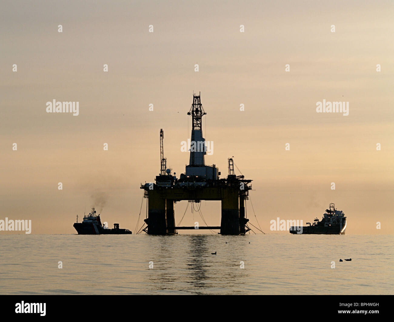 The Transocean Rather, a semi-submersible oil drilling rig, is silhouetted against the dawn, Cromarty Firth, Scotland Stock Photo