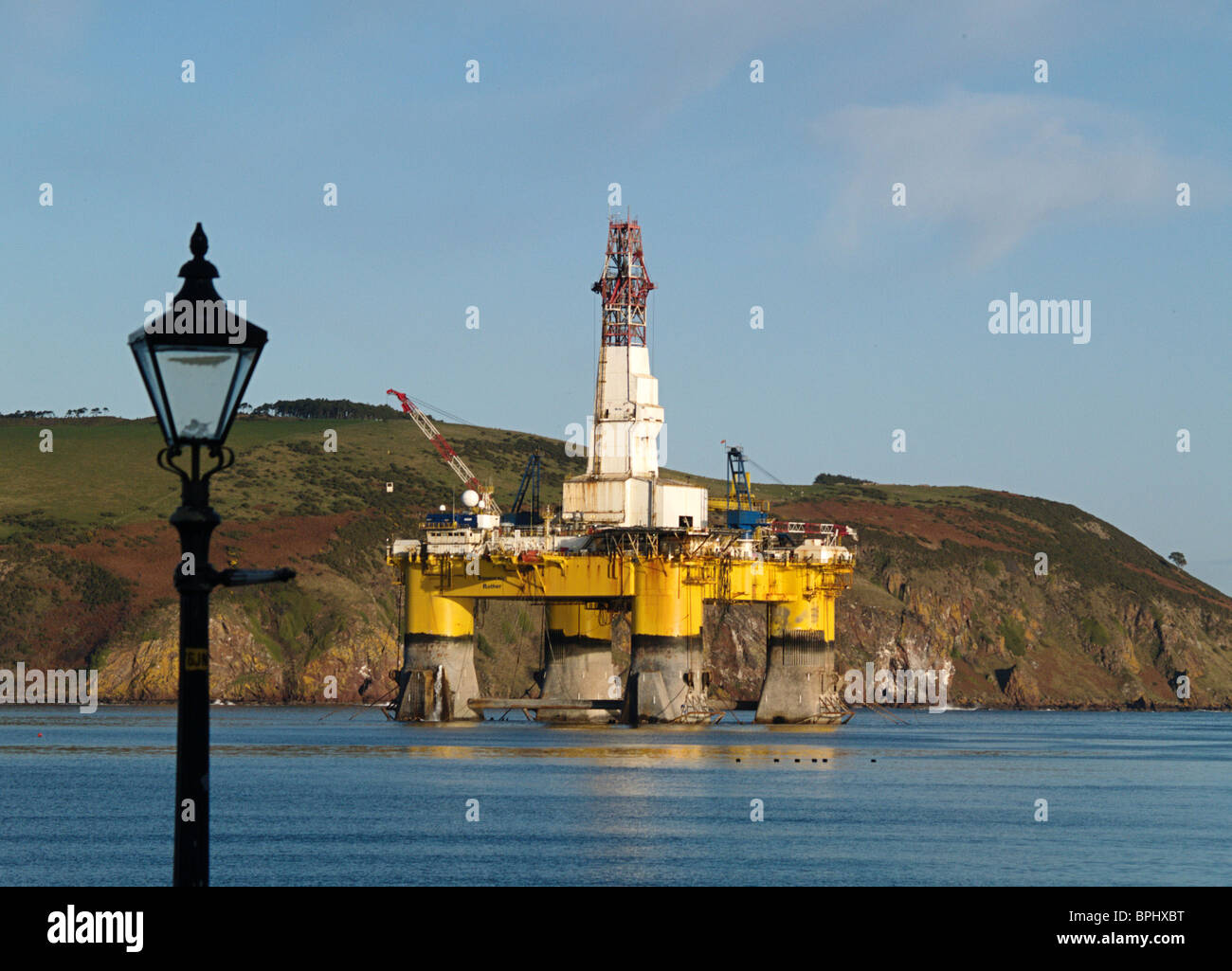 The semi-submersible Oil Drilling rig Transocean Rather moored in the Cromarty Firth, Scotland, framed by an street lamp Stock Photo