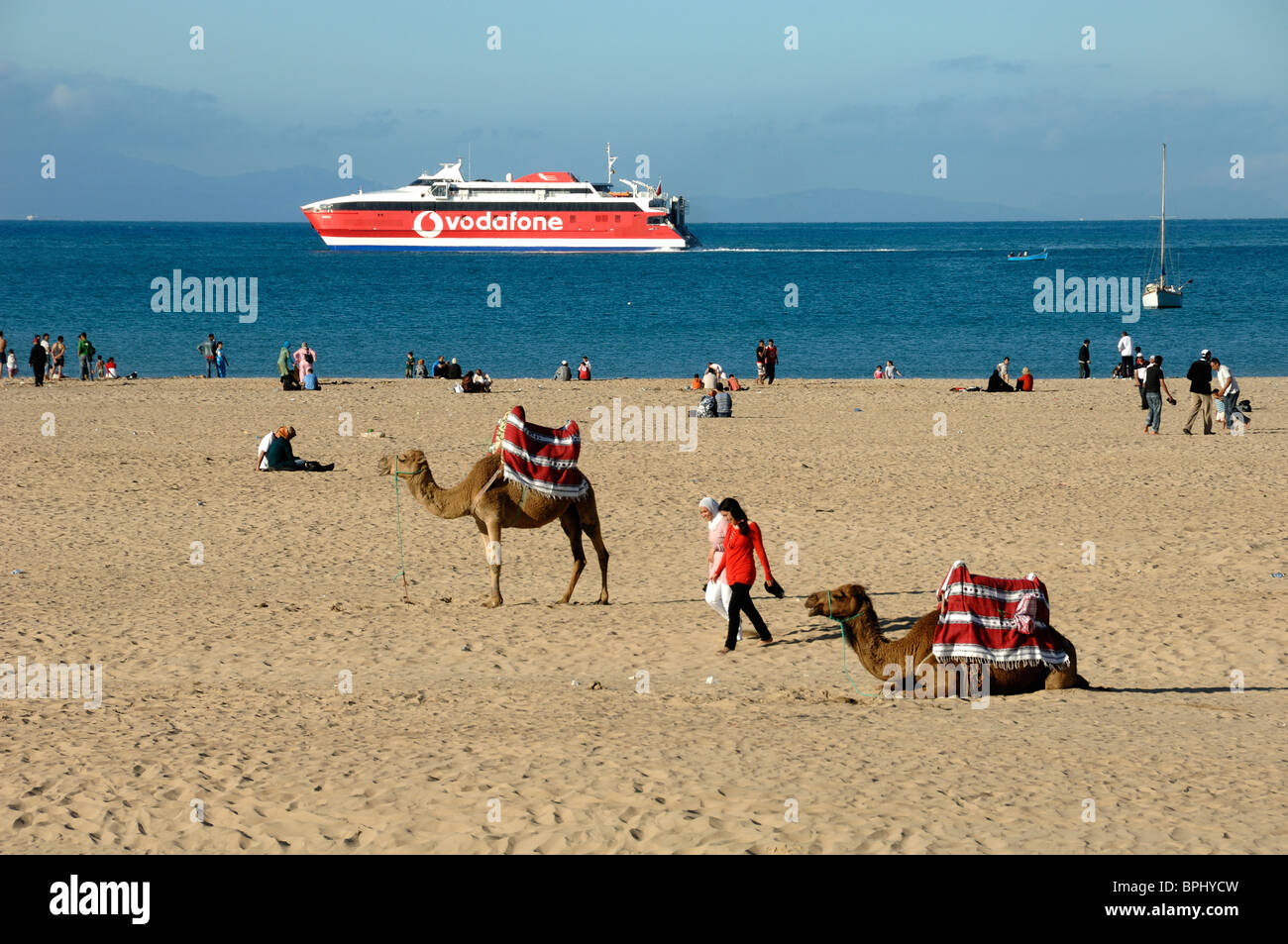 Town Beach, Camels, Moroccan Girls, & Red Cruise Ship or Ferry Boat  Advertising Vodafone, Tangier, Tanger or Tangiers, Morocco Stock Photo -  Alamy