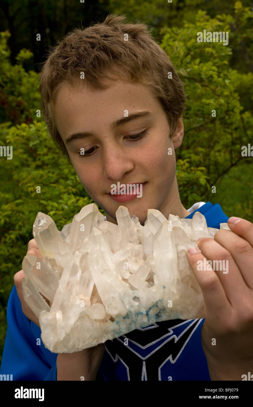 Quartz (SiO2 - silicon dioxide) - The most common mineral on earth - Being held by young man Stock Photo