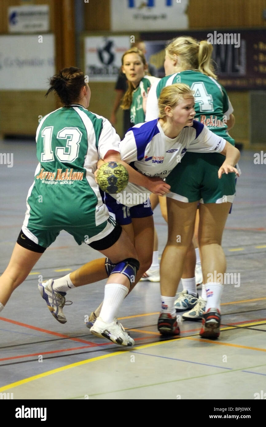 Action photo from a handball game between IFK Nyköping (white and blue) and Mantorps IF (green). Stock Photo