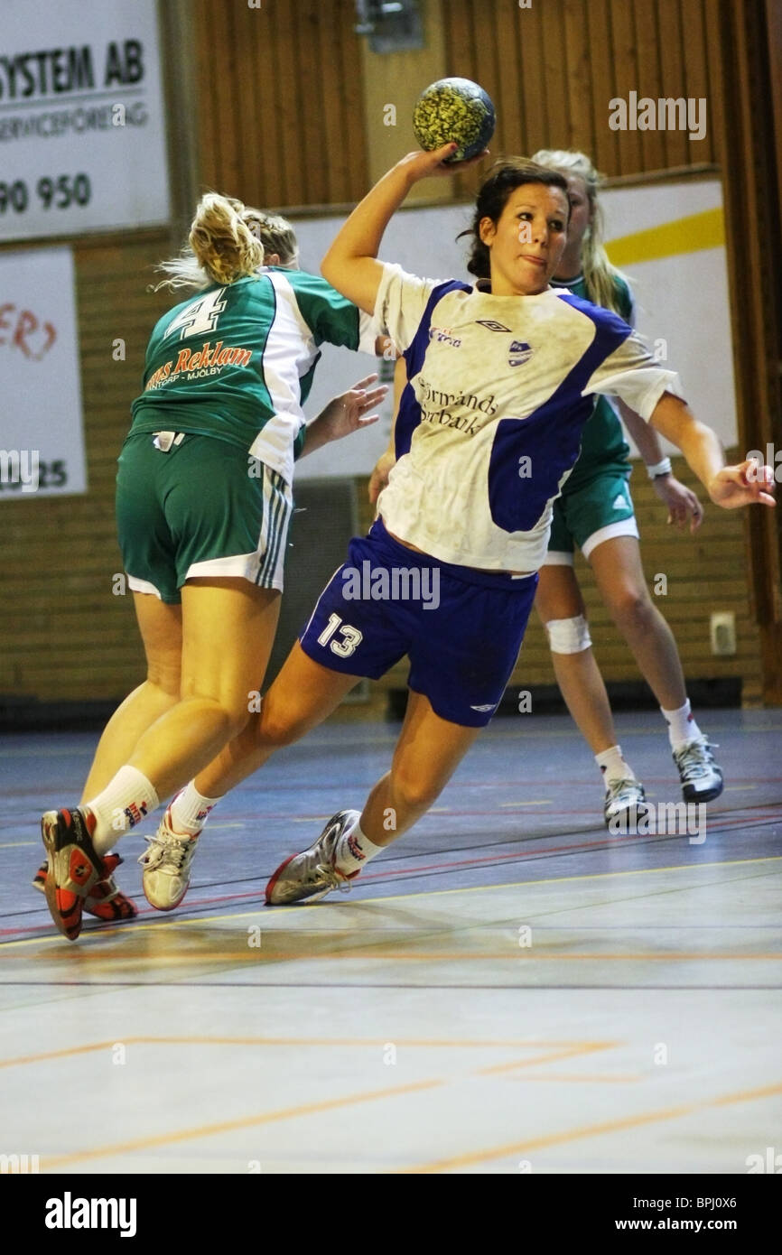 Action photo from a handball game between IFK Nyköping (white and blue) and Mantorps IF (Green). Stock Photo