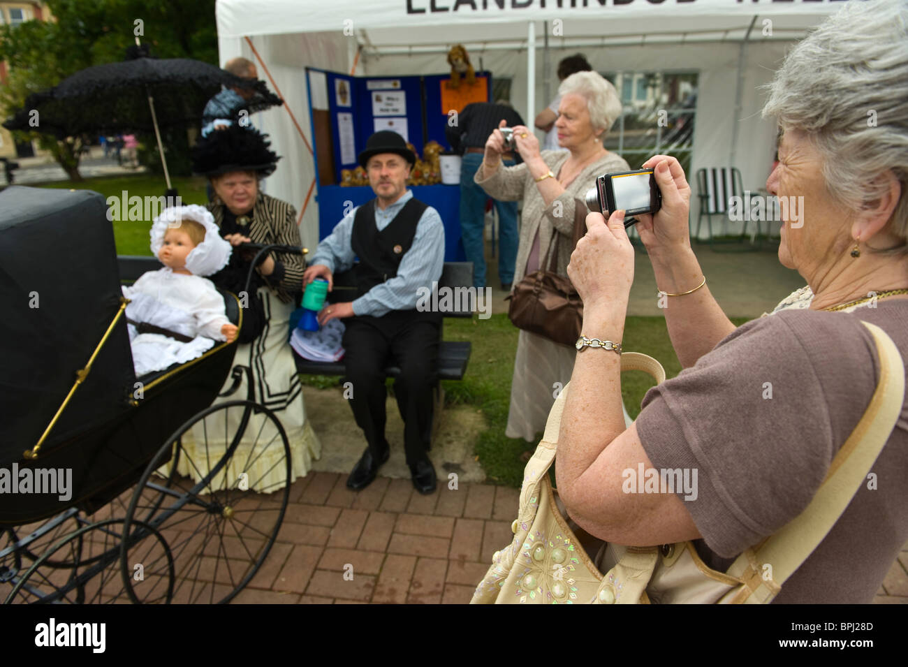Family with baby in pram in period costume being photographed at the Victorian Festival in Llandrindod Wells Powys Mid Wales UK Stock Photo