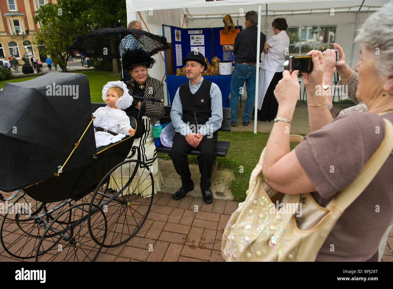 Family with baby in pram in period costume being photographed at the Victorian Festival in Llandrindod Wells Powys Mid Wales UK Stock Photo