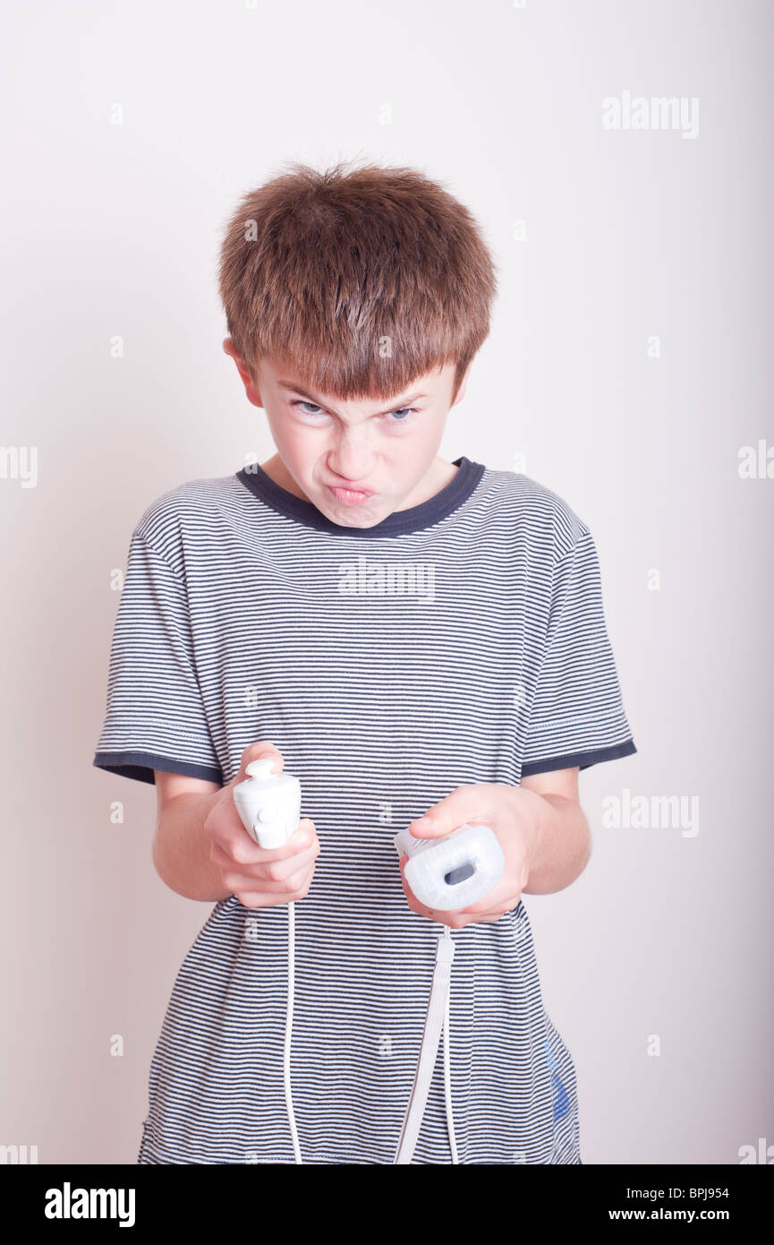 A MODEL RELEASED picture of a 10 year old boy playing with a Nintendo Wii remote and numchuck in the studio Stock Photo