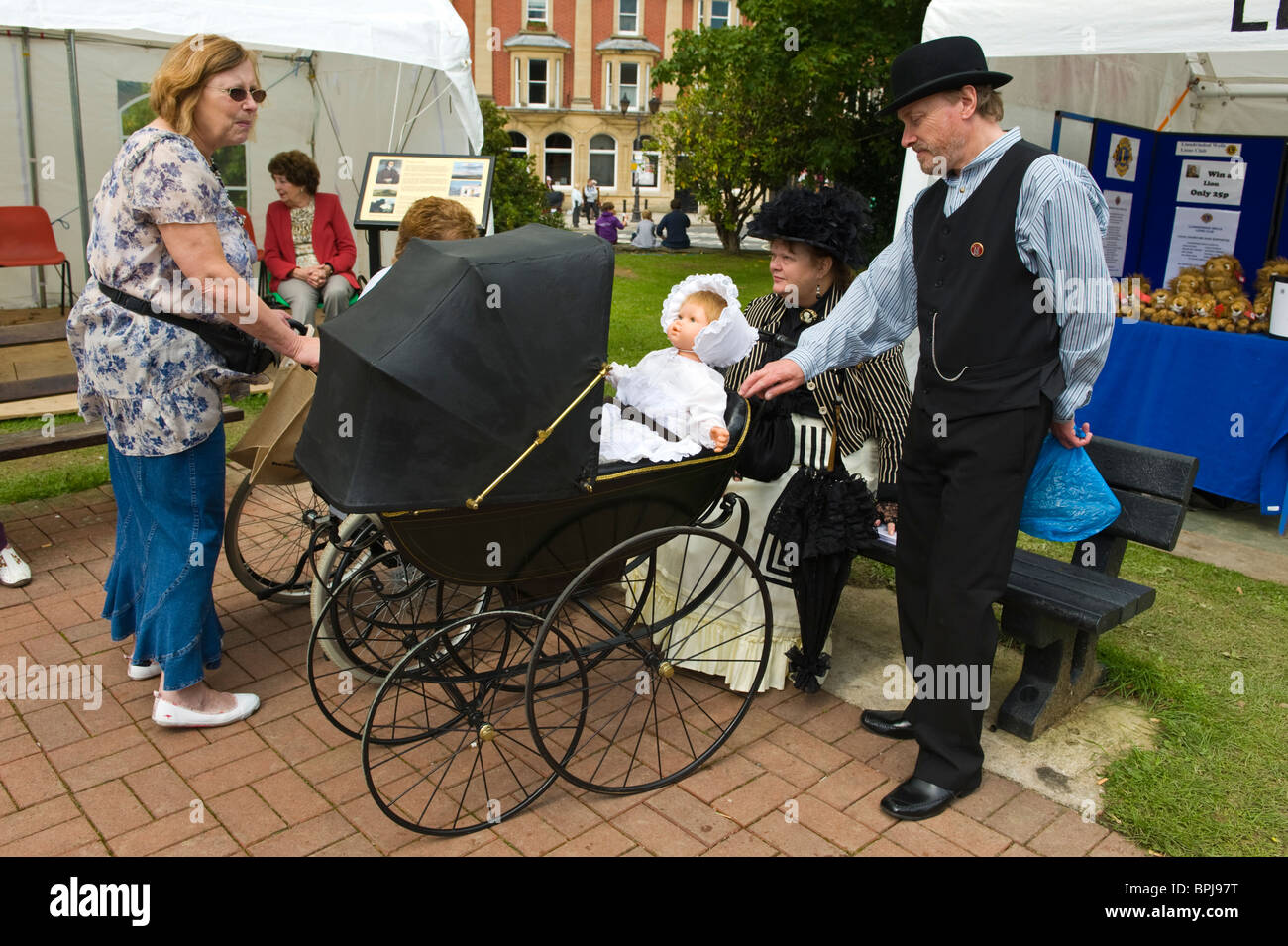 Woman and man with pram in period costume at the annual Victorian Festival in Llandrindod Wells Powys Mid Wales UK Stock Photo