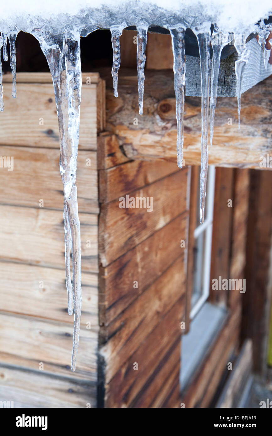 Icicles hanging down from roof Stock Photo