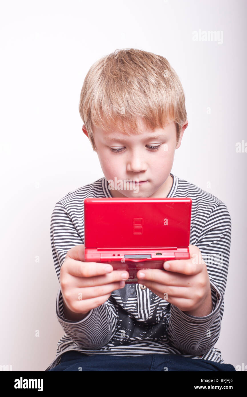 A MODEL RELEASED picture of a 6 year old boy playing with a Nintendo DS