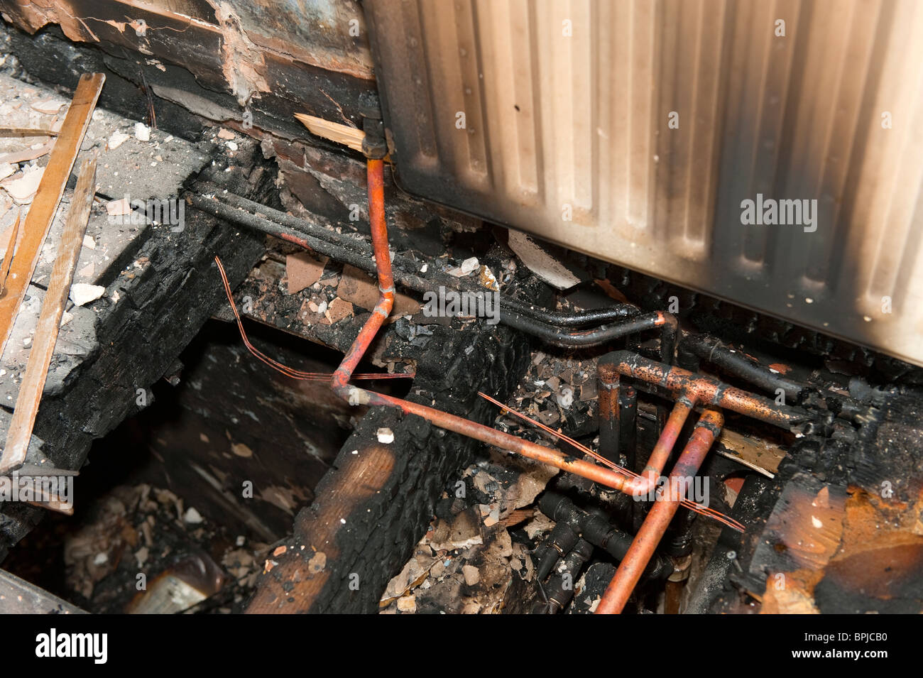 Burnt floor joists and copper pipe in house fire Stock Photo Alamy