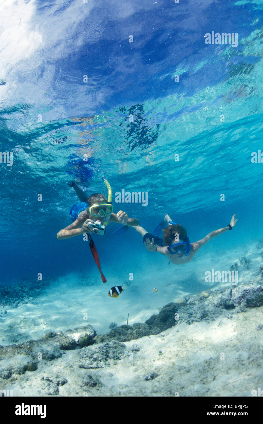 Micronesia, Palau. Boy and girl (age 10) snorkeling with underwater camera Stock Photo