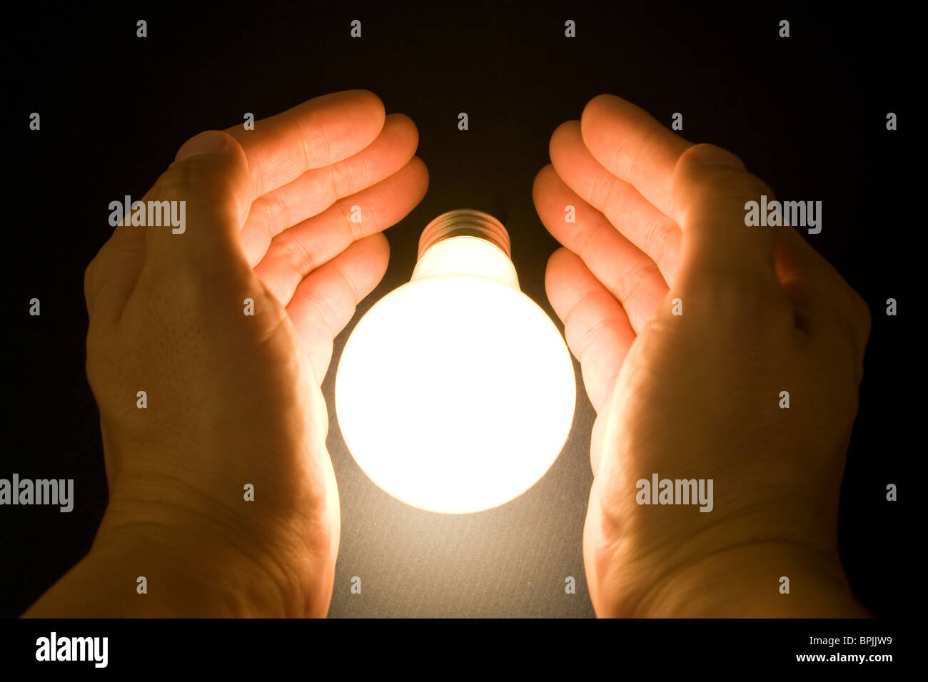 Hand and a Bright Light Bulb, Concept of Inspiration, Ideas Stock Photo