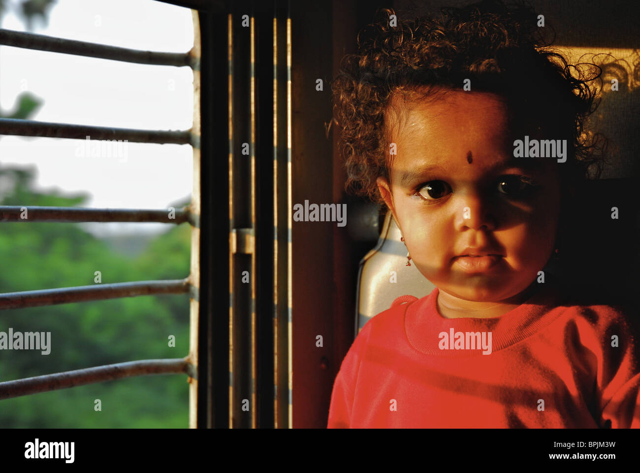 Three year old girl in a train in the morning, second class, India, Asia Stock Photo