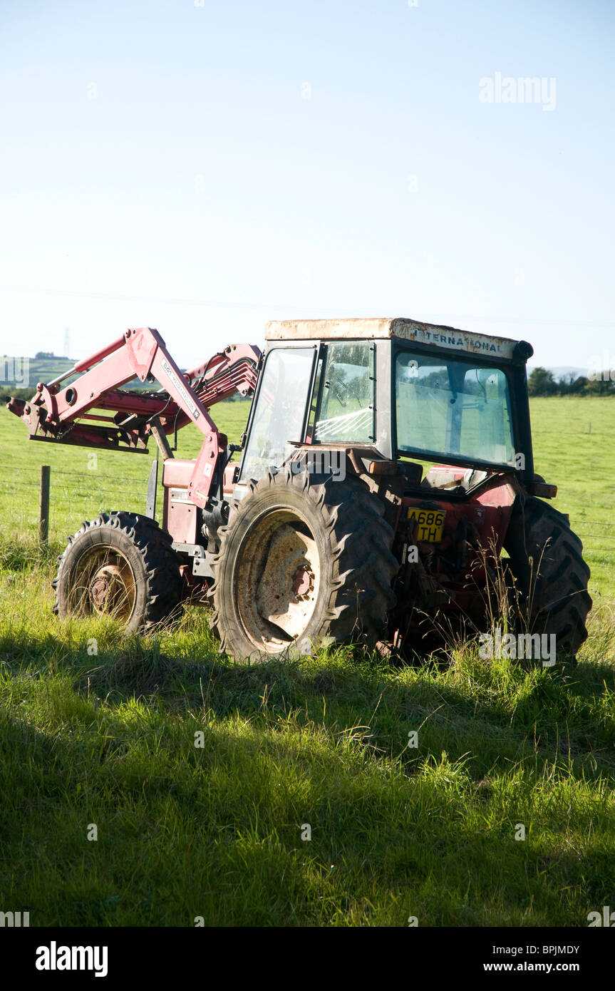 A red tractor parked in field Stock Photo - Alamy