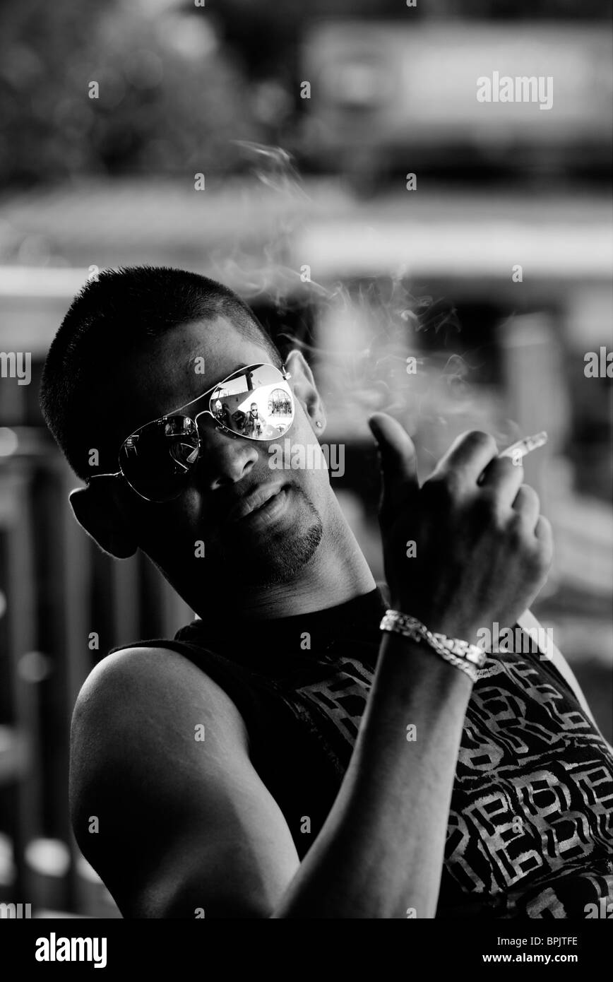 Young Mauritian male smoking, Flic en Flac, Mauritius Stock Photo
