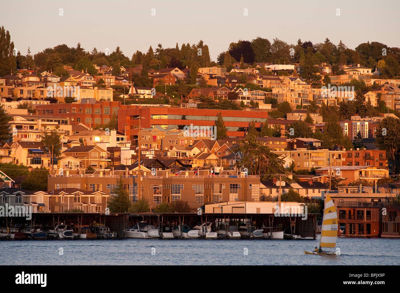 Sunset on Lake Union with sailboat with hillside neighborhood Seattle