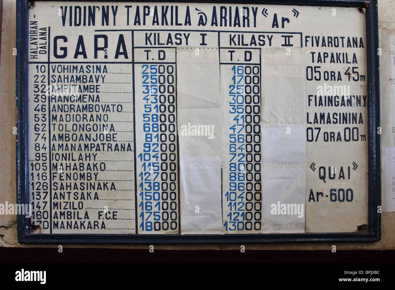 Board showing the stations and prices of the train journey between Manakara and Fianarantsoa, Madagascar. Stock Photo