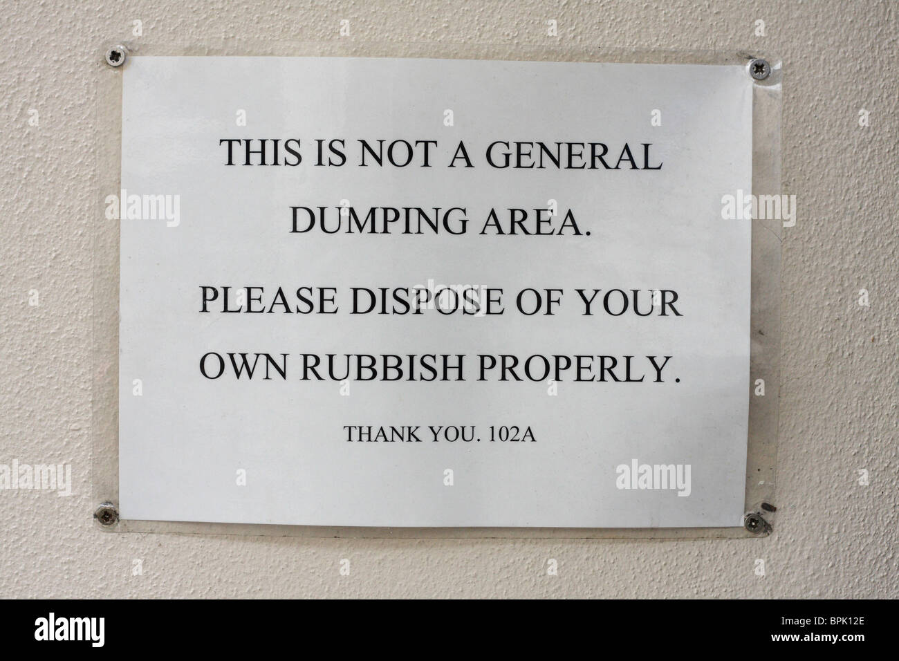 Warning sign posted on building wall Stock Photo