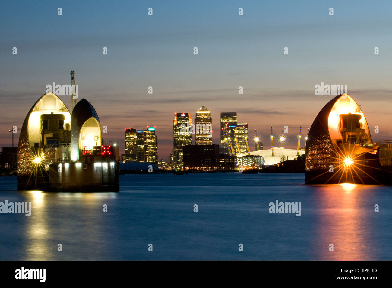 Thames Barrier with Canary Wharf and the O2 at dusk Stock Photo - Alamy