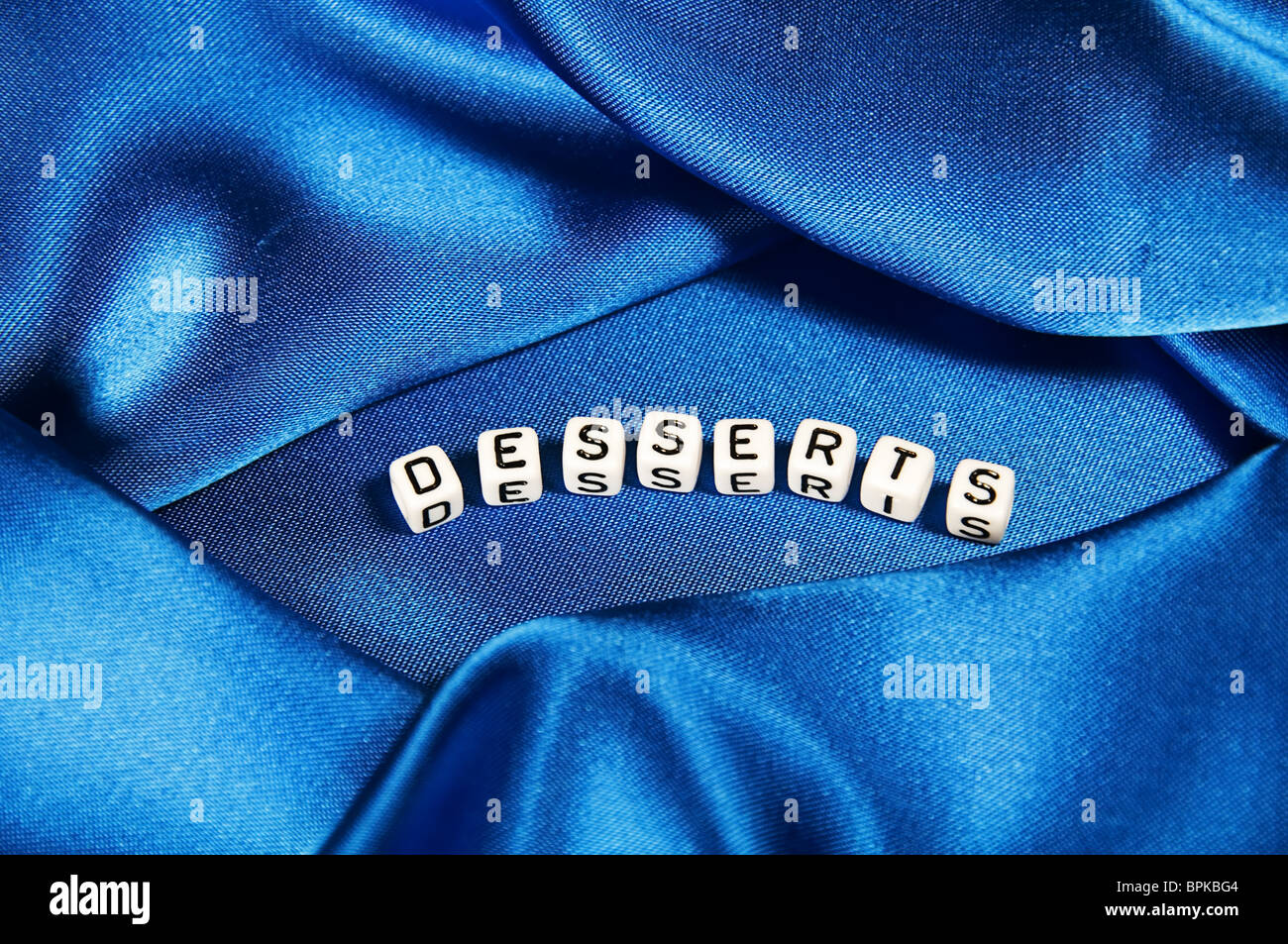 This series has a royal blue shiny background with the word desserts in black and white cube lettering. Stock Photo