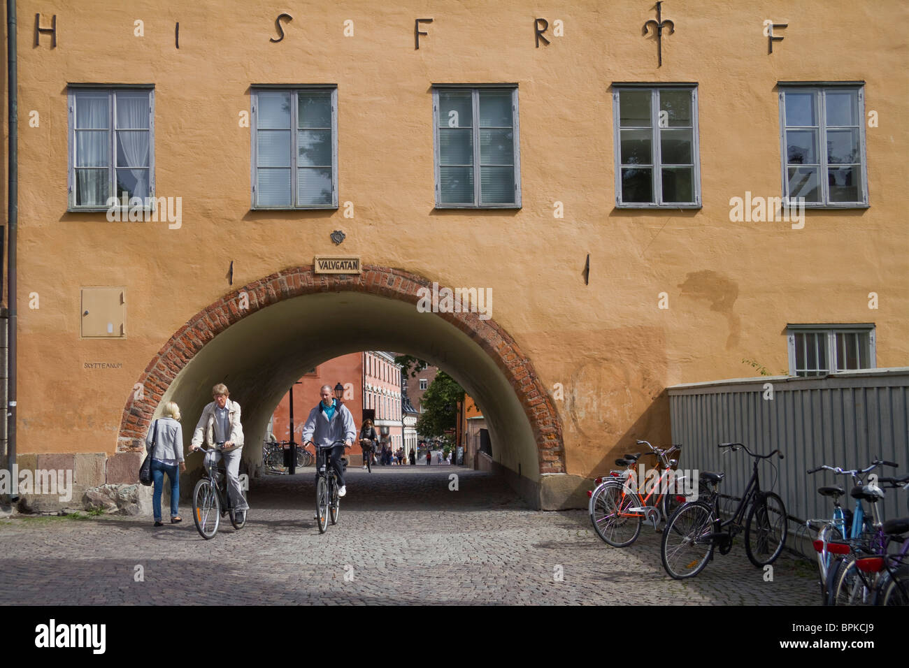 Arch with cyclists in Old City Uppsala Sweden Stock Photo
