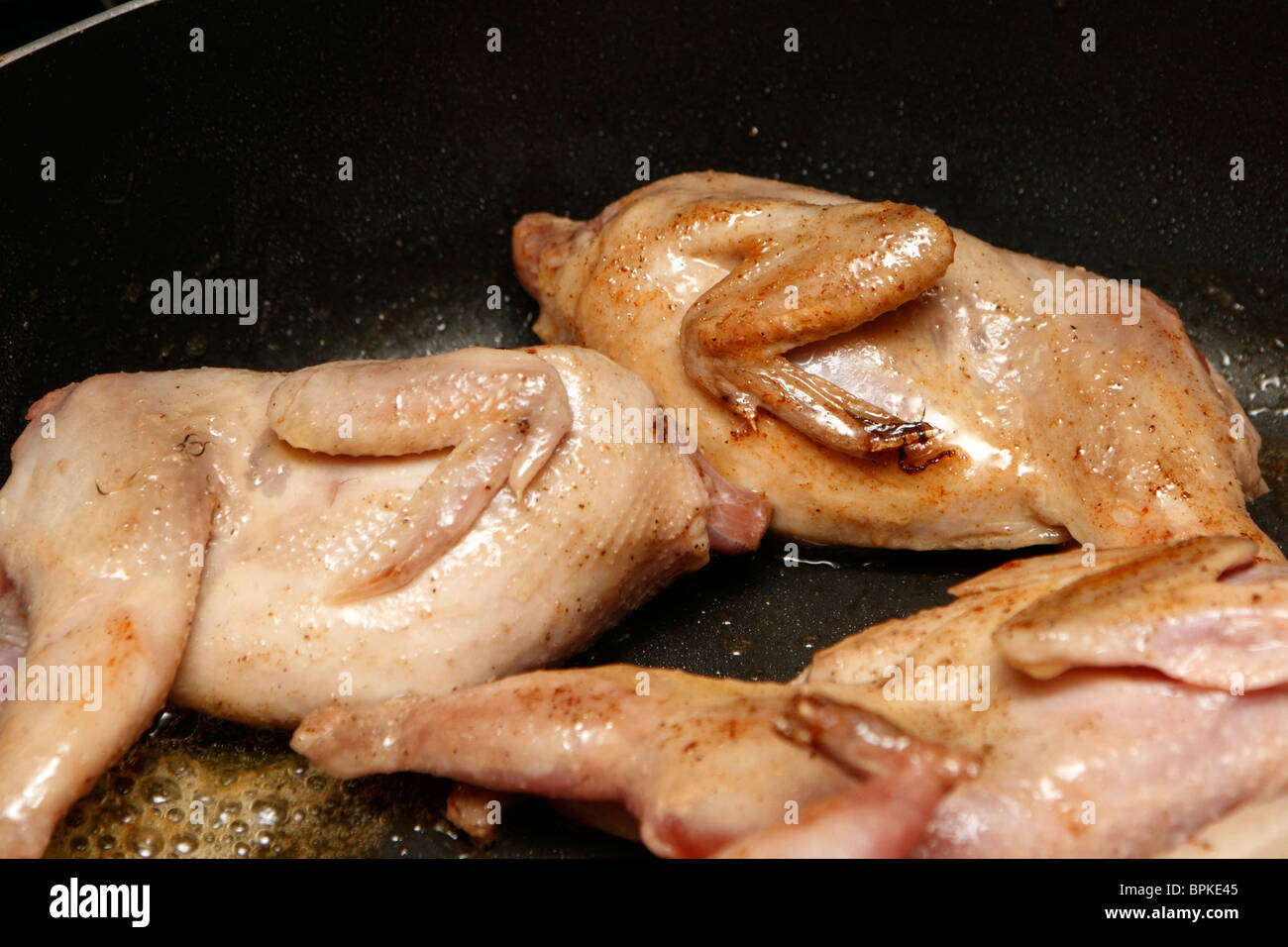 Quails being browned in butter Stock Photo