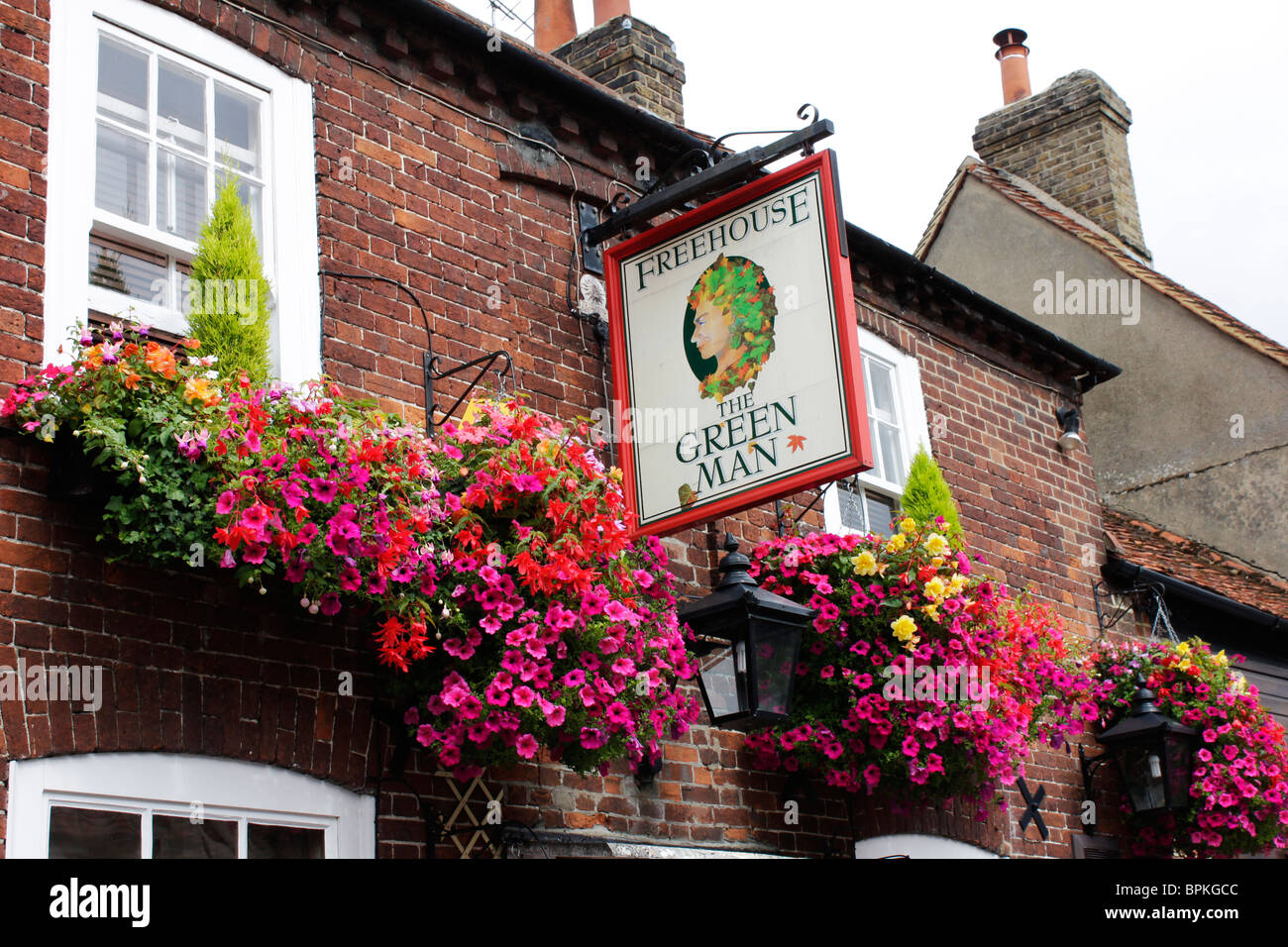 Flowering hanging baskets the front of the Green Man public house in the village of Denham Stock Photo