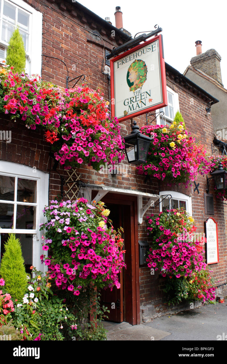 Flowering hanging baskets the front of the Green Man public house in the village of Denham Stock Photo