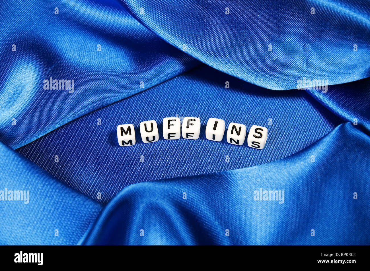 This series has a deep royal blue satin shiny background with the word muffins in  cube lettering in this cooking series. Stock Photo
