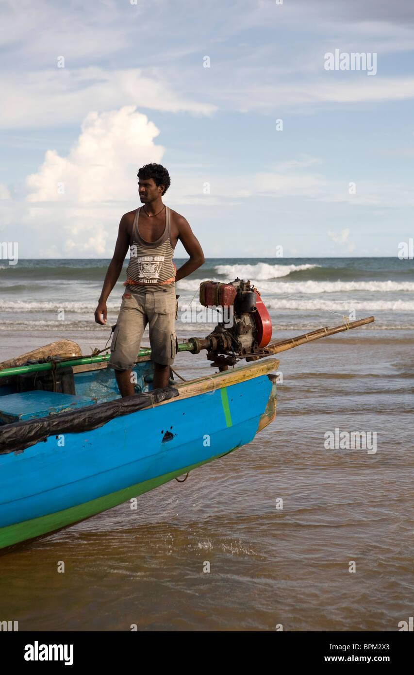 Indian fisherman on his boat on the beach in Gopalpur on-Sea. Stock Photo