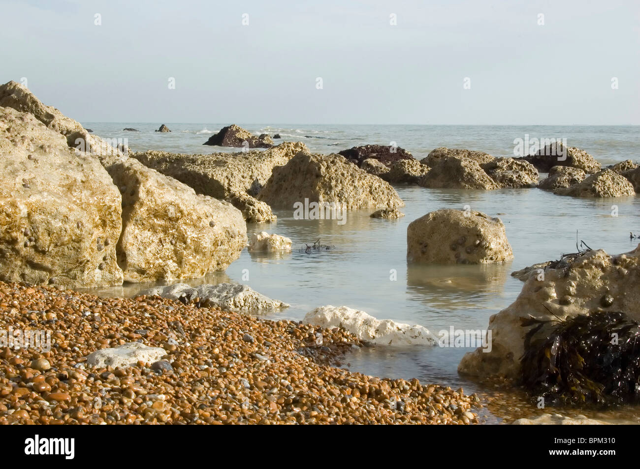 Rocks on the beach with blue sky Stock Photo - Alamy
