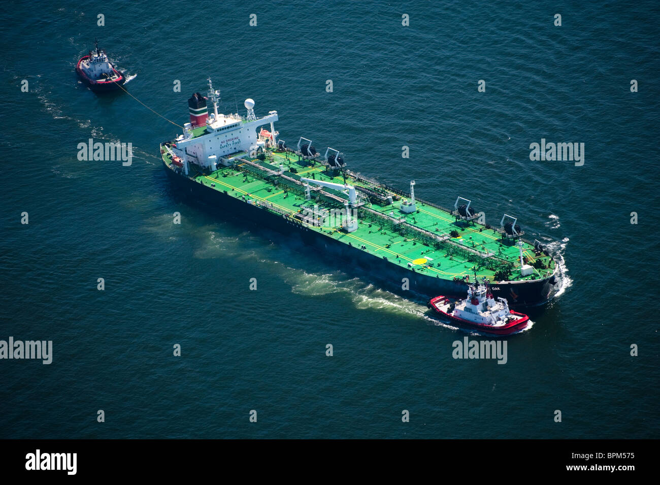 Crowley Maritime Tug Boats and Oil Tanker British Oak, arriving at BP Oil Refinery,Cherry Point Washington, USA Aerial Stock Photo