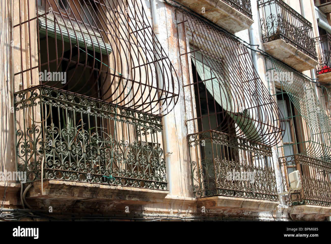 View of windows in Almeria, Spain showing typical wrought iron balcony and window guard or grille Stock Photo
