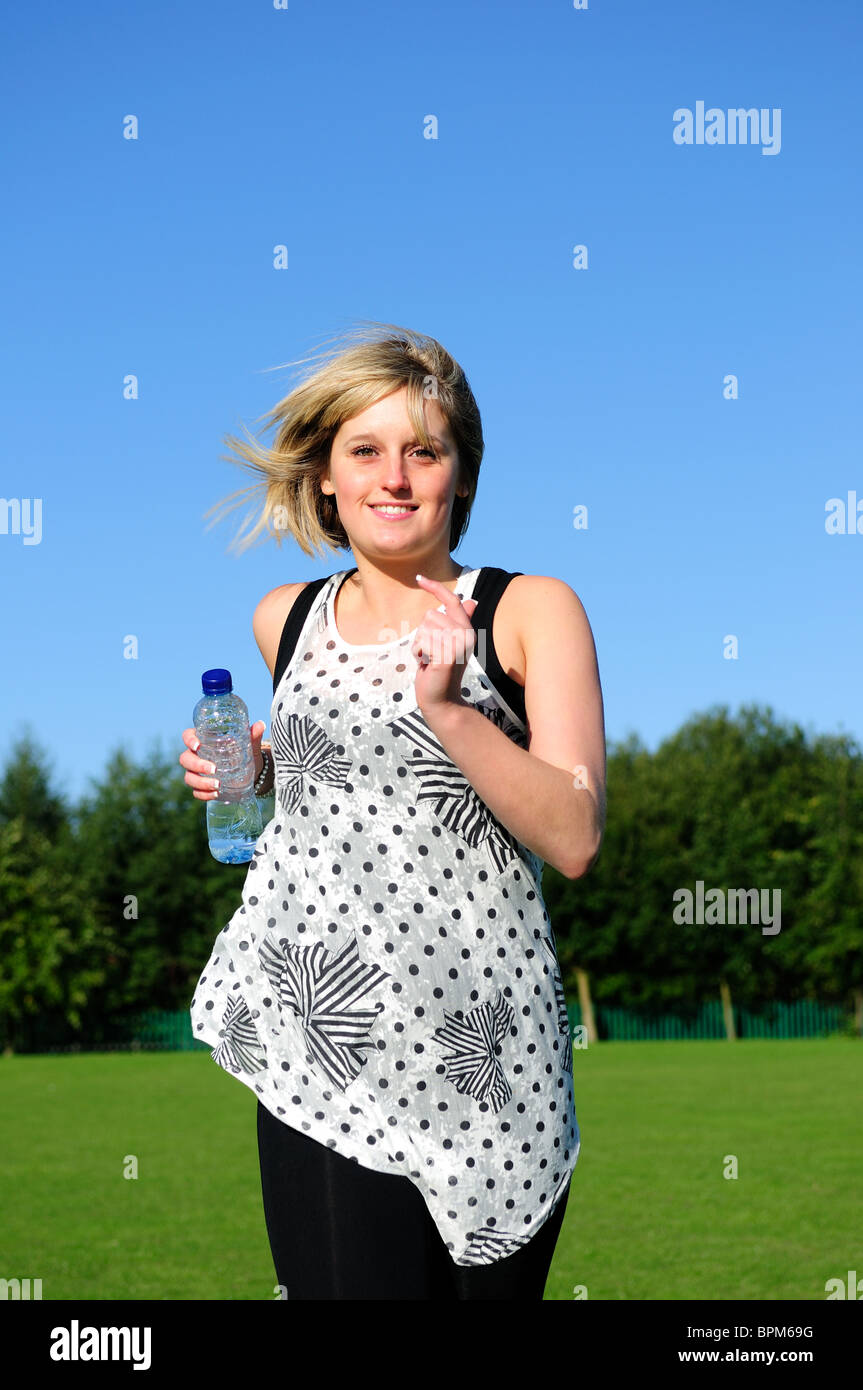 Young Women Jogging While Holding Energy Drink Stock Photo Alamy